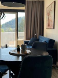 a table and chairs with a coffee cup on top of it at Schöne Aussicht - charmante Ferienwohnung mit Pool und Sauna in Bad Harzburg in Bad Harzburg