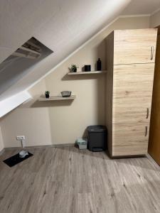 an attic room with a wooden cabinet and a staircase at Eifelnest Stadtkyll in Stadtkyll