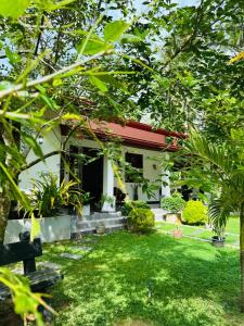 a house with a green yard in front of it at The Garden Grove Villa in Yatiyana +5 photos