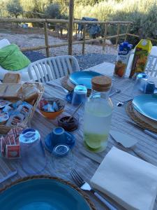 a table with blue plates and a bottle of water at Leukos Home Relais ecoretreait b&b in Diamante +13 photos