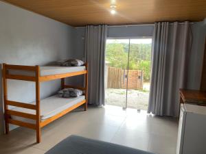 una litera en una habitación con una ventana grande en Pousada Santa Rosa, en Imbituba