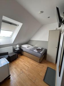 a bedroom with a bed in a attic with a window at Zimmer-Bad-TV-Kühlschrank-14 in Meine