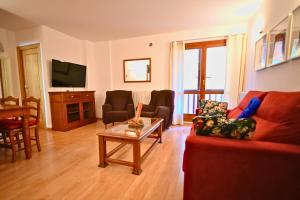 a living room with a red couch and a table at Ski & Vistas I A 2 min de Grandvalira con Parking in Soldeu