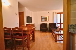 a living room with a table and chairs and a couch at Ski & Vistas I A 2 min de Grandvalira con Parking in Soldeu +25 photos