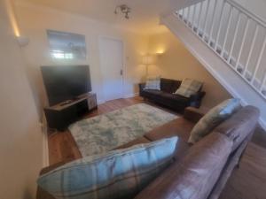 a living room with a couch and a television at Cheerful two bedroom home in Dunfermline in Dunfermline