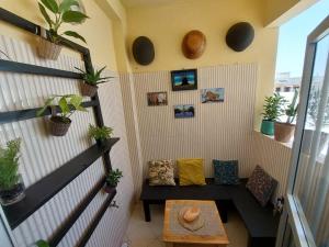 a room with a bench and a table with plants at Saphir in Dakar