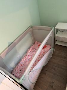 a baby crib with a pink bed in a room at Eifelnest Stadtkyll in Stadtkyll