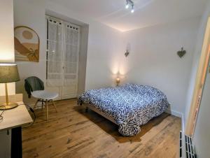 a bedroom with a bed and a table and a chair at Charmant studio rénové hyper centre in Périgueux