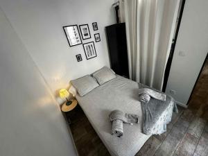a small bedroom with a bed and a lamp at Cosy T2 Côté du Vieux Port & Mucem - central in Marseille
