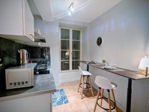 a kitchen with a counter and two stools at Charmant studio rénové hyper centre in Périgueux +2 photos
