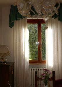 a window with white curtains in a room at Villa Iliana in Lucca