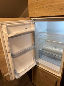 an empty refrigerator with its door open in a kitchen at Eifelnest Stadtkyll in Stadtkyll +11 photos