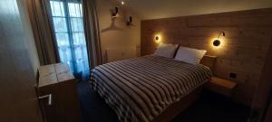 a bedroom with a bed with a wooden headboard at Frostana1600 - apartment in Portes du Soleil in Champoussin