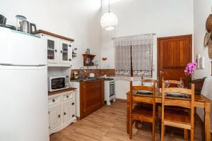 a kitchen with a table and a dining room at Chalé com Churrasqueira a 5min da Praia Estaleiro in Balneário Camboriú +72 photos