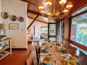 a dining room with a table with chairs and a chandelier at Camarinhas House in Moledo