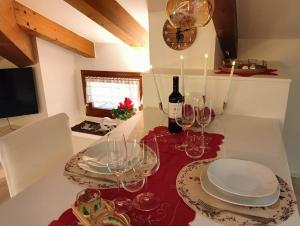 a table with glasses and plates and a bottle of wine at Attico delle Dolomiti in Levico Terme +30 photos