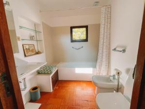 a bathroom with a tub and a toilet and a sink at Camarinhas House in Moledo +37 photos