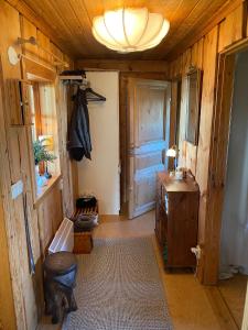 a room with a wooden hallway with a door and a table at Mysig timmerstuga vid sjön Björken in Grangärde