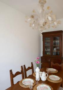 a dining room table with plates and a chandelier at Villa Iliana in Lucca