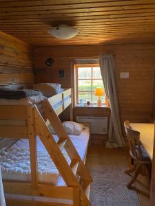 a bedroom with two bunk beds in a cabin at Mysig timmerstuga vid sjön Björken in Grangärde