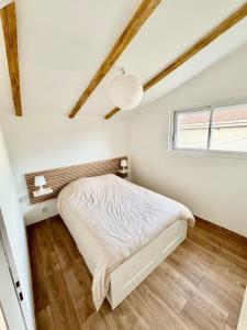 a bedroom with a bed and a window at Nana Bloo in La Teste-de-Buch