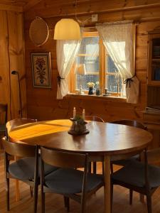 a dining room with a wooden table and chairs at Mysig timmerstuga med sjötomt in Grangärde +16 photos