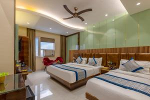 a hotel room with two beds and a ceiling fan at Hotel Vanson Villa, City Centre in New Delhi +80 photos