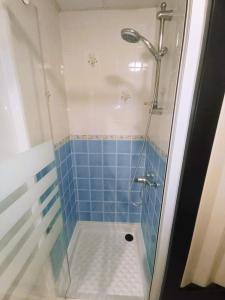 a bathroom with a shower with blue tile at Échappée Belle au pied des Falaises in Le Tréport