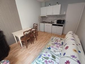 a small kitchen with a table and a bed in a room at Échappée Belle au pied des Falaises in Le Tréport +11 photos