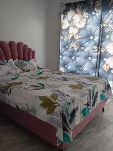 a bedroom with a bed with a floral bedspread at Hergla Diamant Bleu 'Najla' in Hergla +22 photos