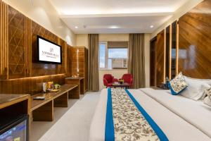 a hotel room with a bed and a flat screen tv at Hotel Vanson Villa, City Centre in New Delhi