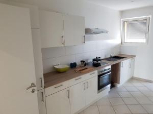 a kitchen with white cabinets and a bowl on the counter at Maison Vauban in Huningue +2 photos