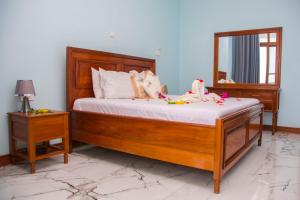Un dormitorio con una cama de madera con flores. en Zamu Beach Villa, en Pwani Mchangani