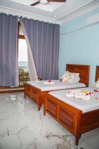 Dos camas individuales en una habitación con ventana. en Zamu Beach Villa, en Pwani Mchangani