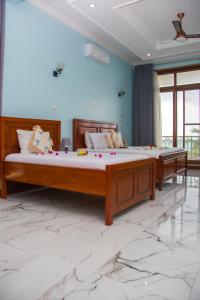 Dos camas en una habitación con suelo de mármol. en Zamu Beach Villa, en Pwani Mchangani