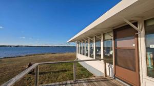 a house on the shore of a body of water at Kellys Point Bayfront Cozy Haven in Stratford
