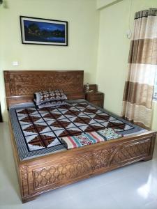 a bed in a room with a wooden bed frame at 4 Bedroom Luxury House in Patantulla Sylhet in Sylhet