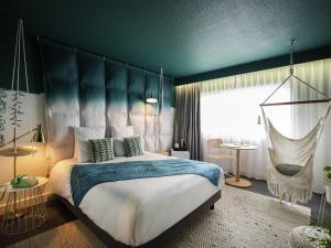 a bedroom with a large bed with a blue ceiling at Mercure Reims Parc Des Expositions in Reims +105 photos