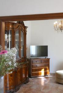 a living room with a tv and a entertainment center at Villa Iliana in Lucca