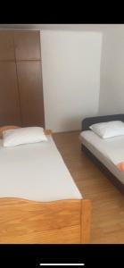 2 aparte bedden in een kamer met houten vloeren bij Apartman CASA MIA in Trebinje