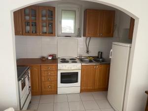 een keuken met een wit fornuis en een koelkast bij Apartman CASA MIA in Trebinje