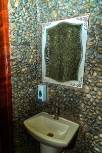 a bathroom with a sink and a mirror at Nzoghu Heritage Safari Camp in Kasese