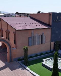 a large building with a garden in front of it at New York Hotel Yerevan in Yerevan