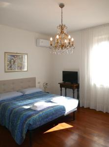 a bedroom with a bed and a chandelier at Villa Iliana in Lucca