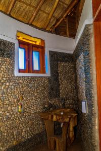 a room with a window and a stone wall at Nzoghu Heritage Safari Camp in Kasese