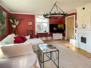 una sala de estar con paredes rojas y una lámpara de araña. en 9 person holiday home in Bellö-By Traum, en Bellö