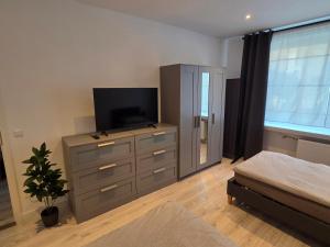 a bedroom with a dresser with a television on it at JONALU - saniert - zentral - voll ausgestattet - 4 Personen - TOP in Celle