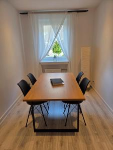 a dining room table with chairs and a window at JONALU - saniert - zentral - voll ausgestattet - 4 Personen - TOP in Celle