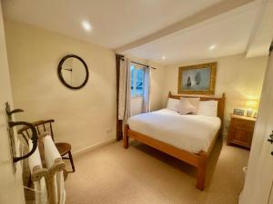 a bedroom with a bed and a mirror on the wall at Manor Cottage in Cavendish