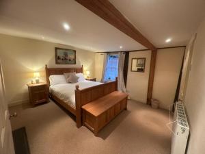 a bedroom with a large bed and a window at Manor Cottage in Cavendish
